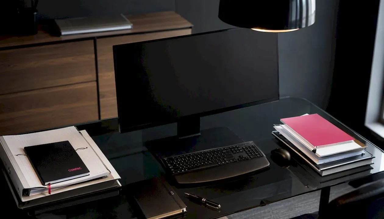Un monitor spento appoggiato sulla scrivania dell’ufficio tecnico, in un ambiente industriale.
