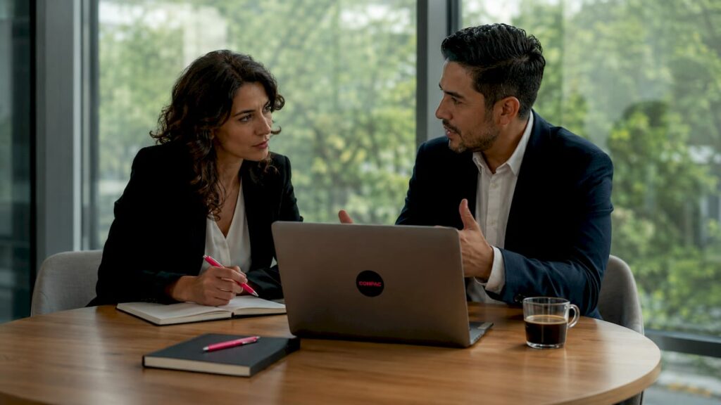 Un manager partecipa a una riunione strategica all'interno di un moderno ufficio industriale, discutendo piani e obiettivi con il suo team.