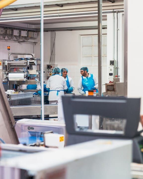 Operatori al lavoro su una linea di produzione all’interno di uno stabilimento industriale.